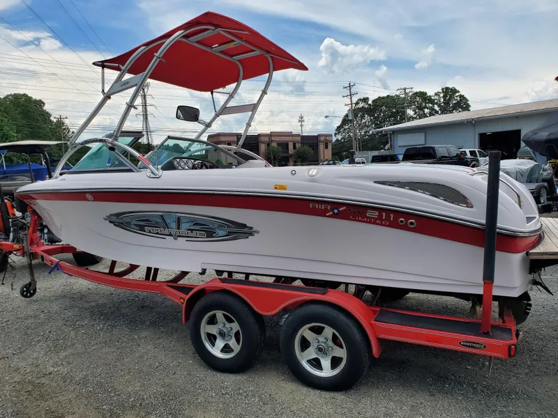 Slide: The Image of 2005 Correct Craft SV-211 Limited boat on red trailer, parked outdoors. - 1