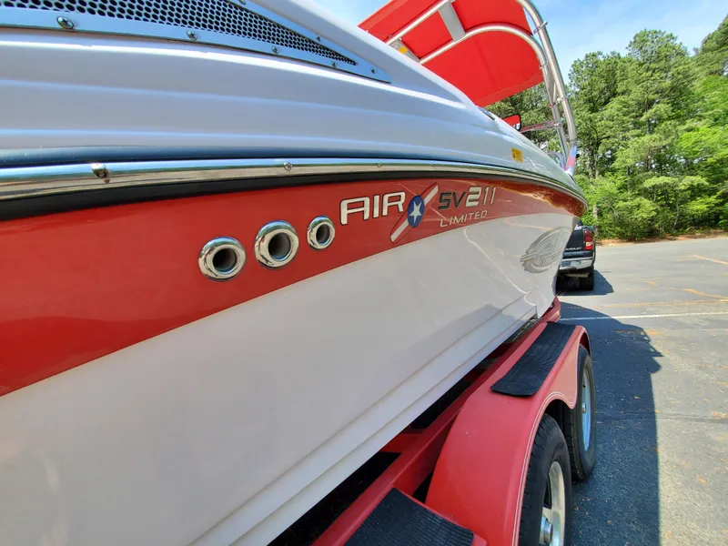 Slide: The Image of 2005 Correct Craft SV-211 Limited boat on red trailer, parked outdoors. - 10