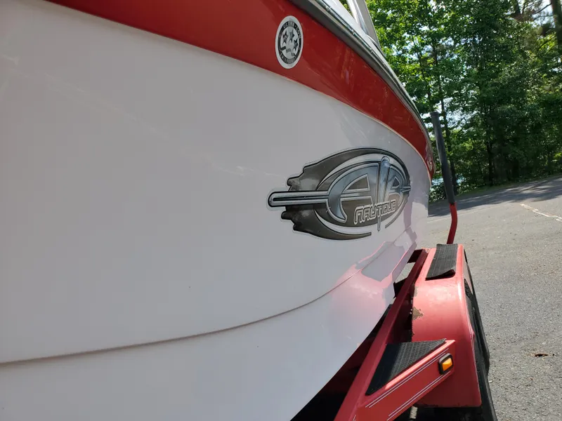 Slide: The Image of 2005 Correct Craft SV-211 Limited boat on trailer, close-up of logo and red accents. - 12
