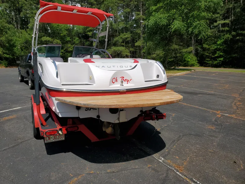 Slide: The Image of 2005 Correct Craft SV-211 Limited boat with red accents in a parking lot. - 16