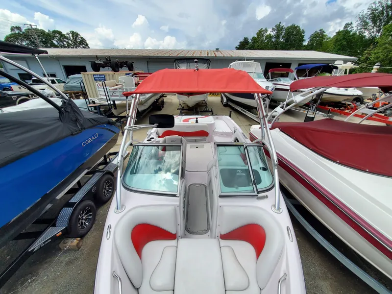 Slide: The Image of 2005 Correct Craft SV-211 Limited boat with red canopy, docked among other boats. - 18