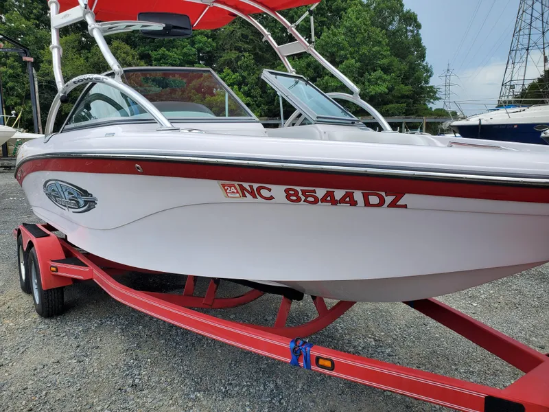 Slide: The Image of 2005 Correct Craft SV-211 Limited boat on red trailer, parked outdoors. - 2