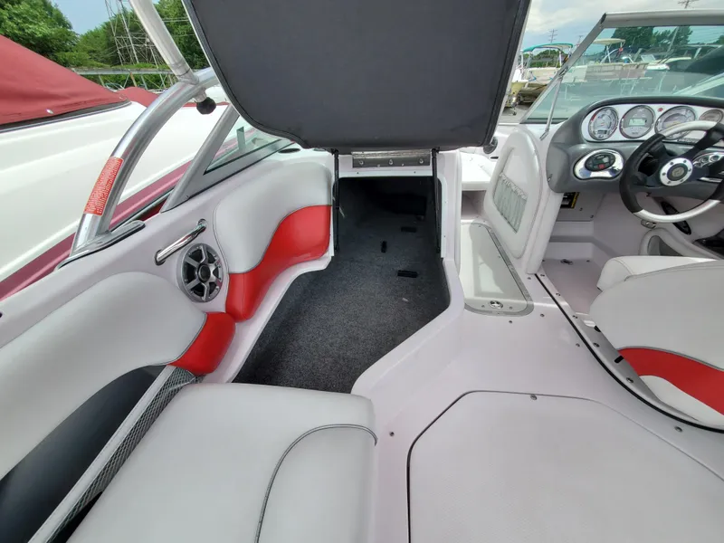 Slide: The Image of 2005 Correct Craft SV-211 Limited boat interior with red and white seating, dashboard, and speaker. - 21