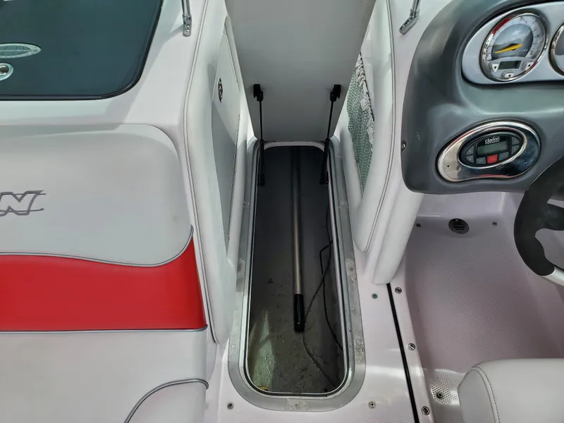 Slide: The Image of 2005 Correct Craft SV-211 Limited boat interior with storage compartment and dashboard controls. - 23