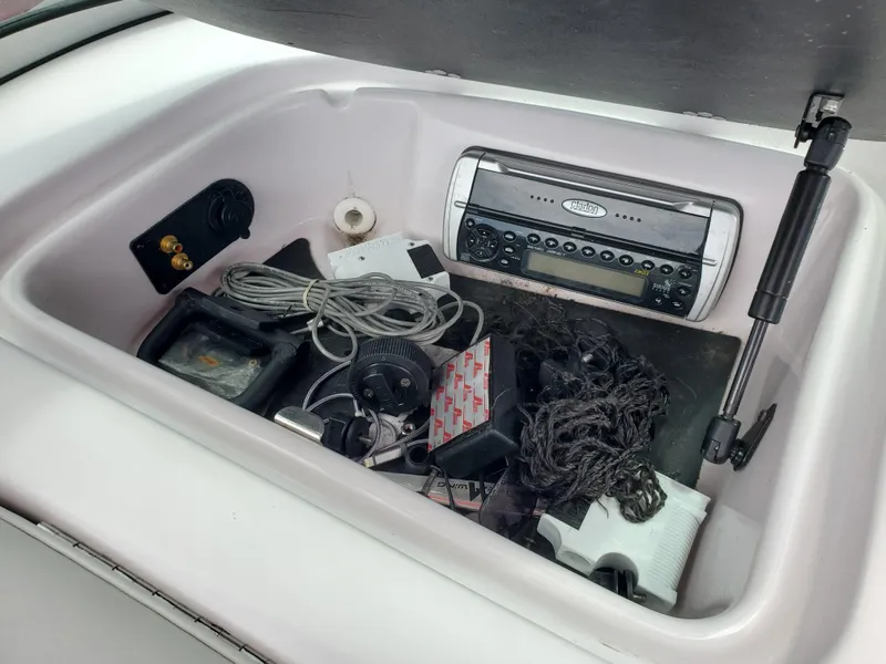 Slide: The Image of Storage compartment in a 2005 Correct Craft SV-211 Limited boat with various equipment. - 28