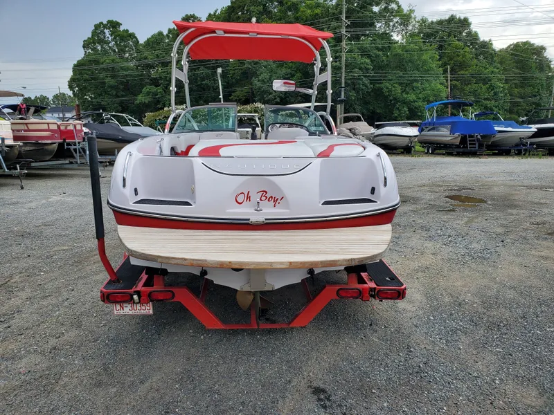 Slide: The Image of 2005 Correct Craft SV-211 Limited boat with red accents, rear view in a boatyard. - 4