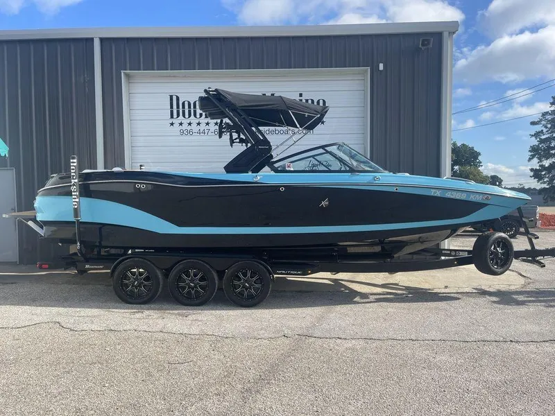 Slide: The Image of 2022 MasterCraft X26 boat on a trailer outside a storage facility. - 0