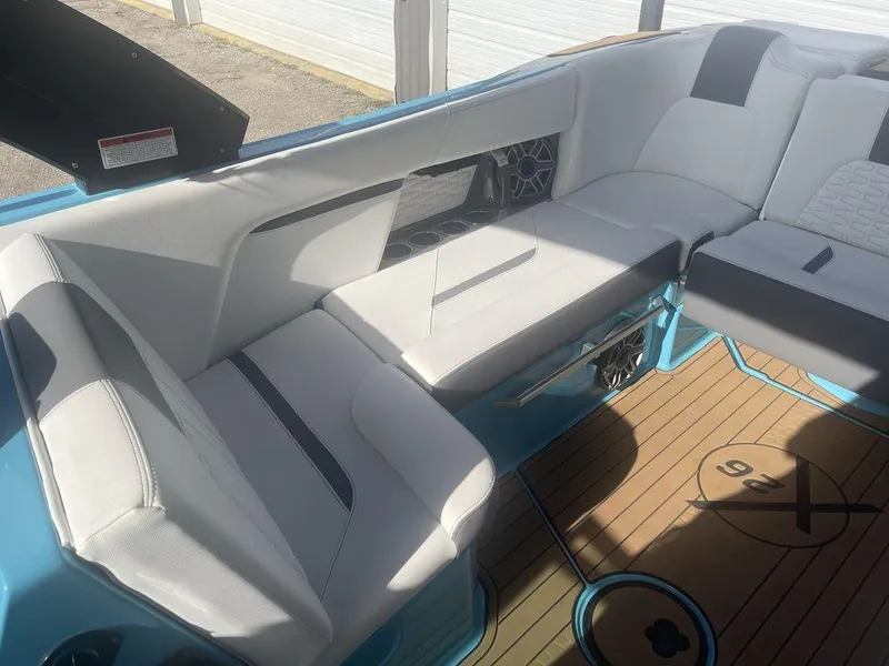 Slide: The Image of 2022 MasterCraft X26 boat interior with white seating and teak flooring. - 10