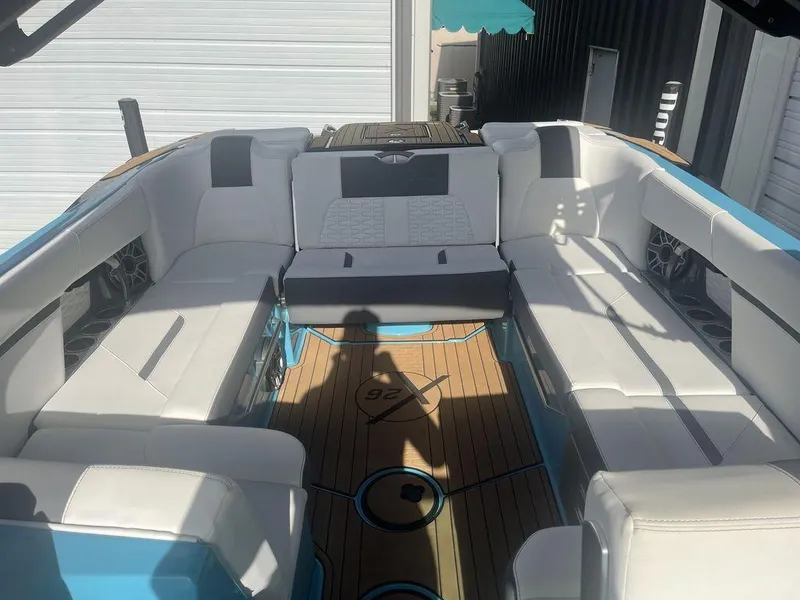 Slide: The Image of 2022 MasterCraft X26 boat interior with white seating and teak flooring. - 11
