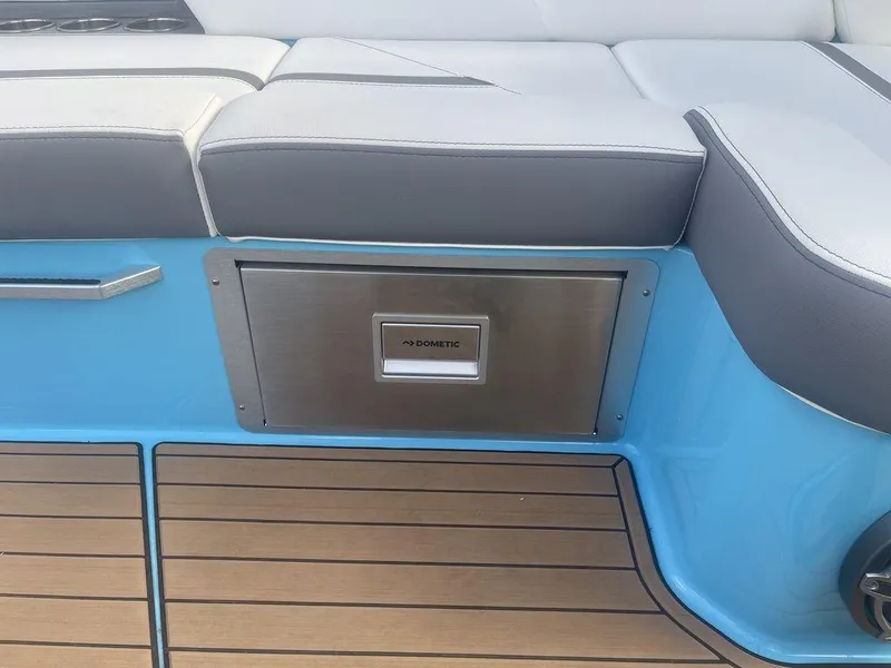 Slide: The Image of 2022 MasterCraft X26 boat interior with Dometic stainless steel drawer and cushioned seating. - 12
