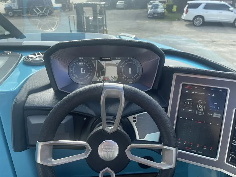 Slide: The Image of 2022 MasterCraft X26 dashboard with digital displays and steering wheel. - 13