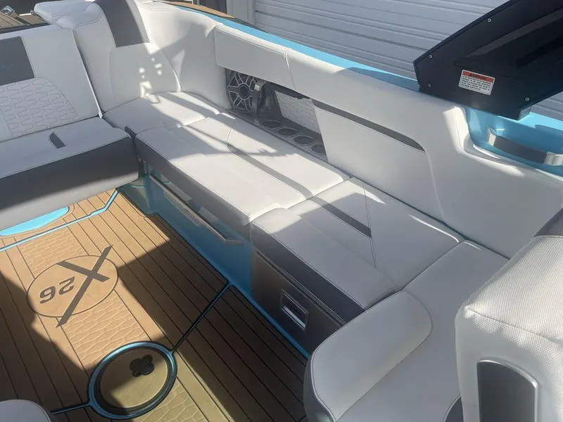 Slide: The Image of 2022 MasterCraft X26 boat interior with white and gray seating and teak flooring. - 9