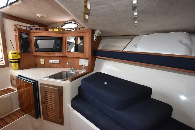 Slide: The Image of 2001 Carolina Classic Express with Marlin Tower interior, featuring kitchenette and seating area. - 13