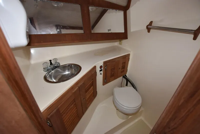 Slide: The Image of 2001 Carolina Classic Express with Marlin Tower bathroom featuring sink, toilet, and wooden cabinets. - 14
