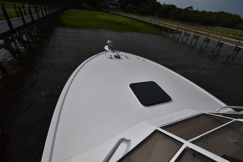 Slide: The Image of 2001 Carolina Classic Express with Marlin Tower boat on calm water near a dock. - 3