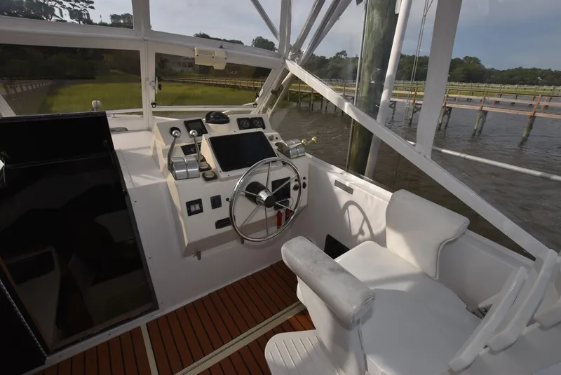 Slide: The Image of 2001 Carolina Classic Express with Marlin Tower boat cockpit, featuring steering wheel and control panel. - 5