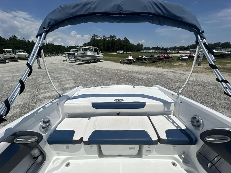 Slide: The Image of 2017 Tahoe 500 TF boat with blue canopy and white seating at a marina. - 3