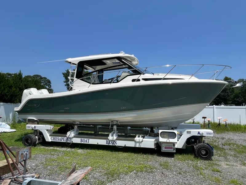 The Image of 2025 Boston Whaler 325 Conquest boat on trailer under clear blue sky. - 0