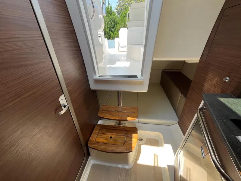 Slide: The Image of Interior of 2025 Boston Whaler 325 Conquest, featuring wooden accents and modern design. - 11
