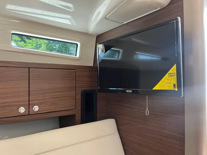 Slide: The Image of Interior of 2025 Boston Whaler 325 Conquest with TV and wooden cabinetry. - 12
