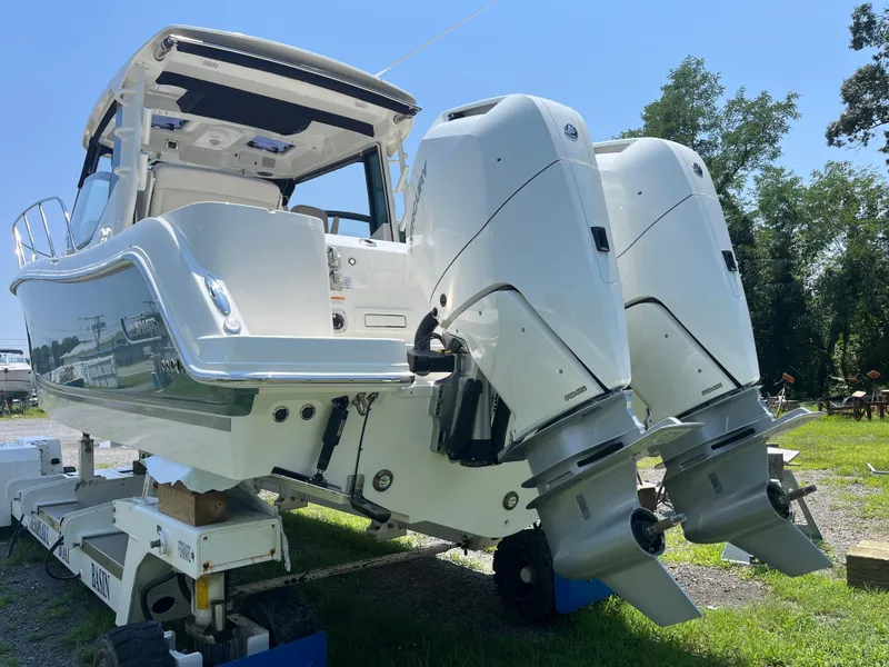 Slide: The Image of 2025 Boston Whaler 325 Conquest with dual outboard engines on display outdoors. - 2