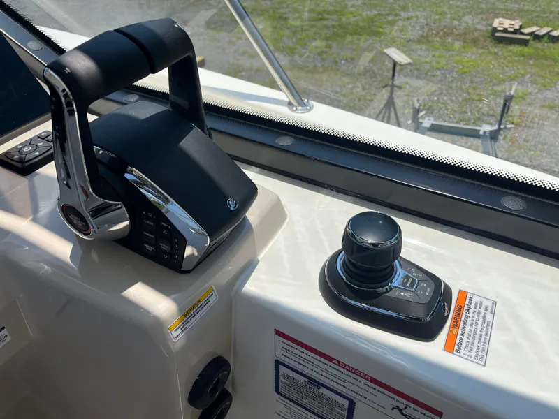 Slide: The Image of Control panel of 2025 Boston Whaler 325 Conquest boat, featuring throttle and joystick. - 23