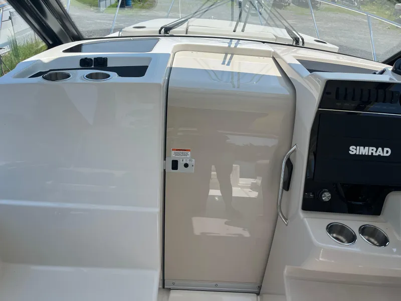 Slide: The Image of 2025 Boston Whaler 325 Conquest helm with Simrad electronics and cup holders. - 24