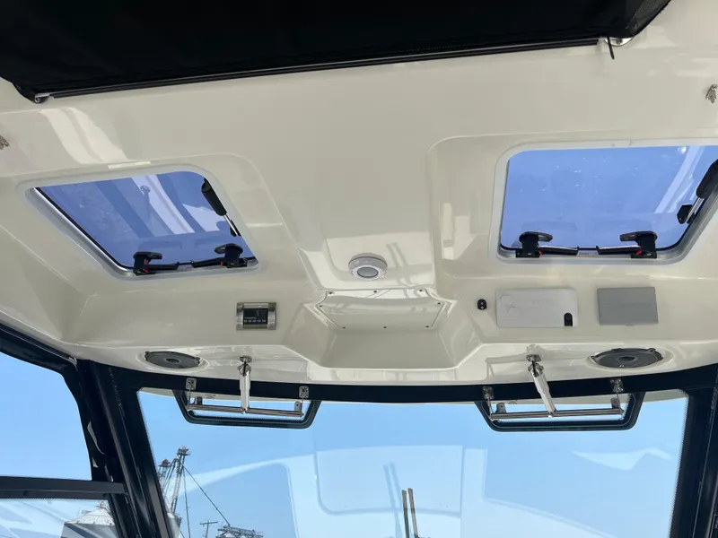 Slide: The Image of Interior view of 2025 Boston Whaler 325 Conquest boat ceiling with skylights and controls. - 26