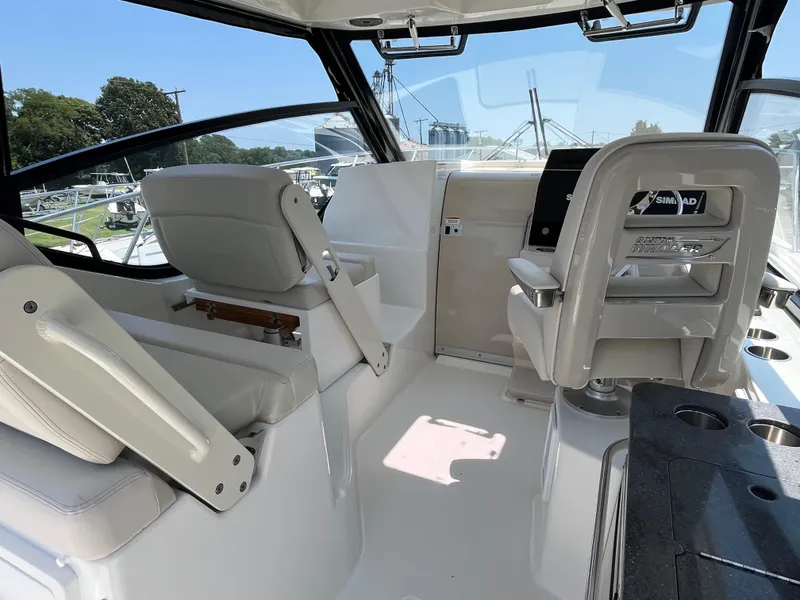 Slide: The Image of 2025 Boston Whaler 325 Conquest cockpit with modern seating and navigation equipment. - 28