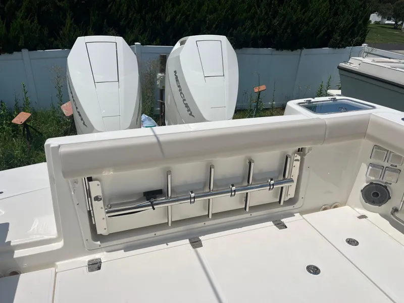 Slide: The Image of 2025 Boston Whaler 325 Conquest boat deck with Mercury engines and fishing rod holders. - 36