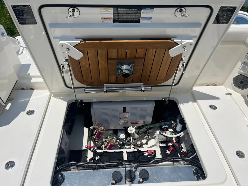 Slide: The Image of Open engine compartment of 2025 Boston Whaler 325 Conquest boat, showcasing internal components. - 37