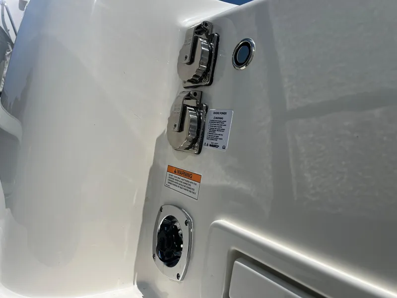 Slide: The Image of 2025 Boston Whaler 325 Conquest boat power connections and warning labels. - 43