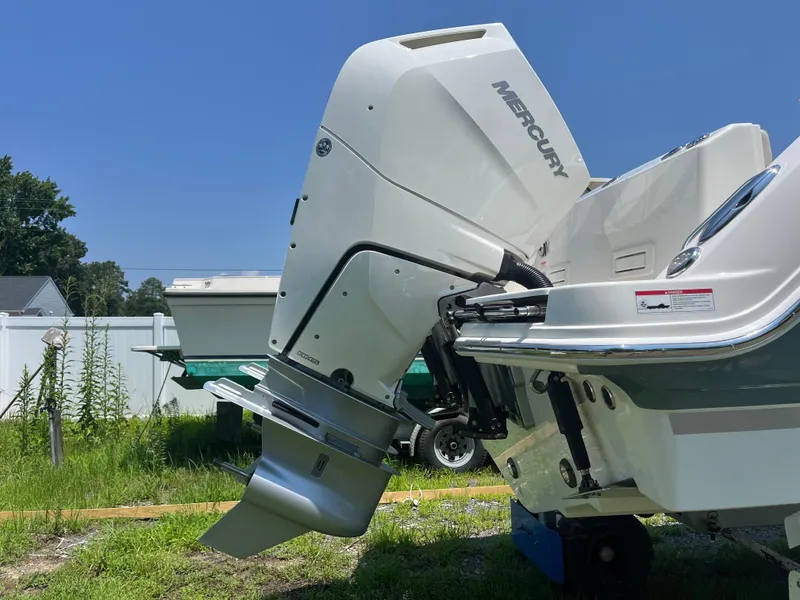 Slide: The Image of 2025 Boston Whaler 325 Conquest with Mercury outboard engine, displayed outdoors. - 49