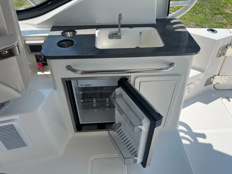 Slide: The Image of Kitchenette on 2025 Boston Whaler 325 Conquest with sink and mini fridge. - 7
