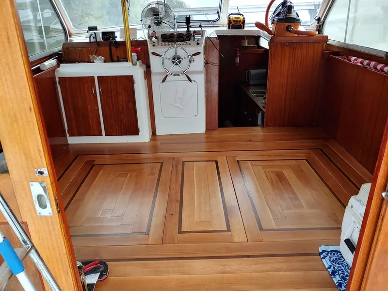 Slide: The Image of Interior of a 1961 Hatteras Convertible boat with polished wooden flooring. - 11