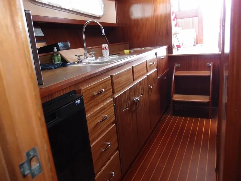 Slide: The Image of 1961 Hatteras Convertible boat kitchen with wooden cabinets and flooring. - 16