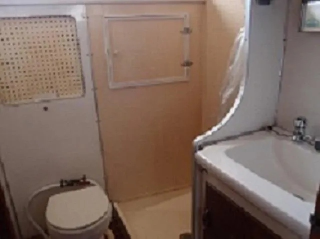 Slide: The Image of 1961 Hatteras Convertible boat bathroom with toilet, sink, and shower. - 21