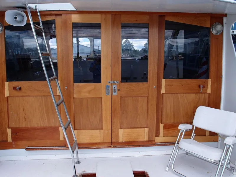 Slide: The Image of 1961 Hatteras Convertible boat with wooden doors and a metal ladder. - 9