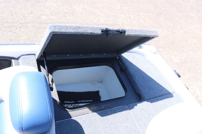 Slide: The Image of Open storage compartment on a 2009 Skeeter 20i boat, featuring a cushioned seat. - 15