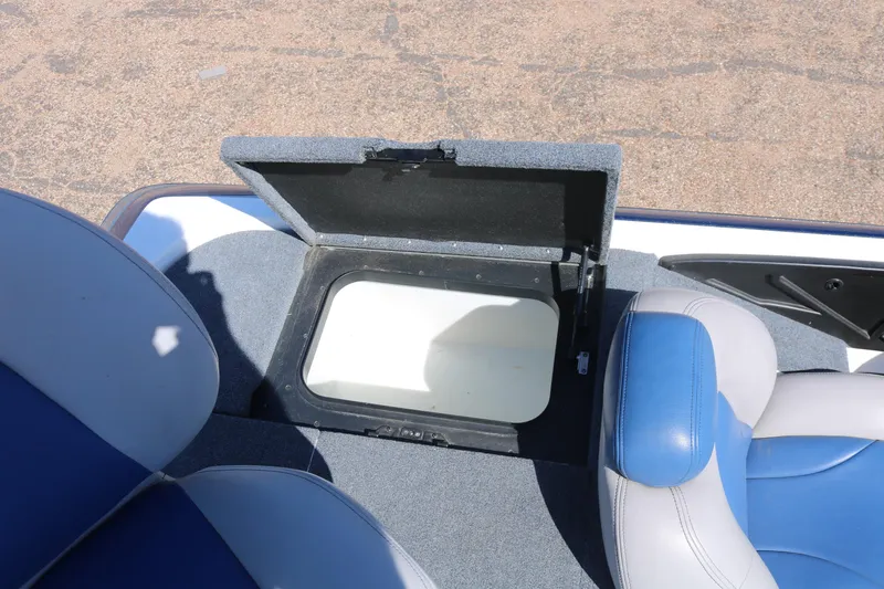 Slide: The Image of 2009 Skeeter 20i boat storage compartment with open lid, blue and white seating. - 16
