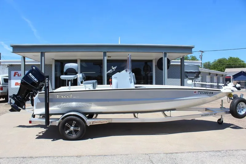 Slide: The Image of 2022 Excel Bay Pro 203 boat on trailer, parked outside a building. - 12