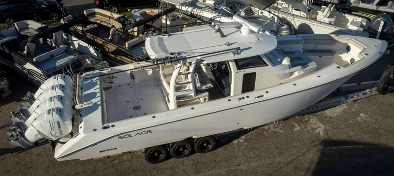 Slide: The Image of 2023 Solace 41 CS boat with triple engines, docked in a marina. - 2
