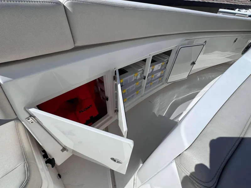 Slide: The Image of Storage compartments on a 2023 Solace 41 CS boat, featuring organized tackle boxes and safety gear. - 33