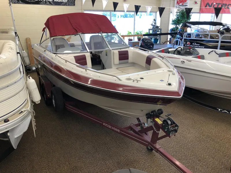 The Image of 1992 Four Winns 220 Horizon Open Bow boat with maroon and white interior on display. - 0