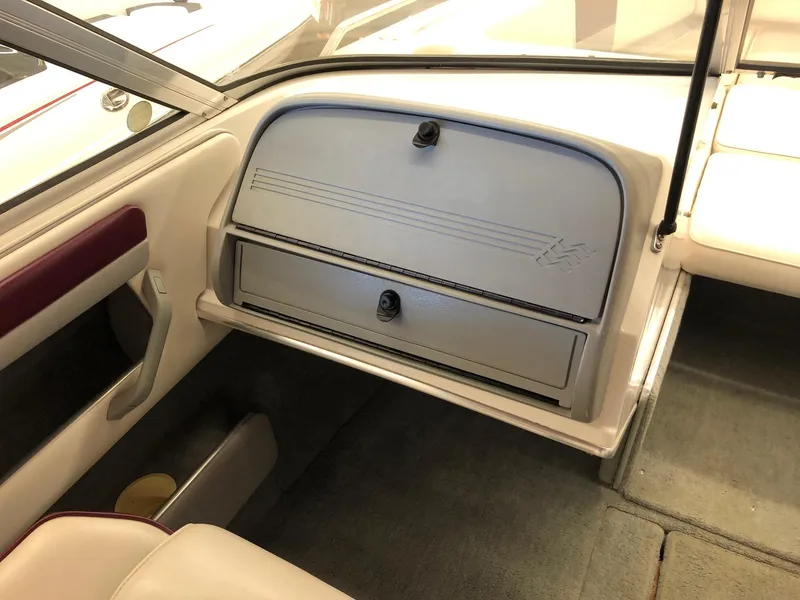 Slide: The Image of 1992 Four Winns 220 Horizon Open Bow boat interior, featuring glove compartment and seating area. - 12