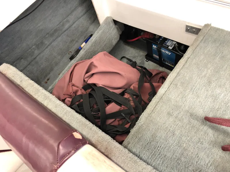 Slide: The Image of Storage compartment of a 1992 Four Winns 220 Horizon Open Bow boat with battery and gear. - 8