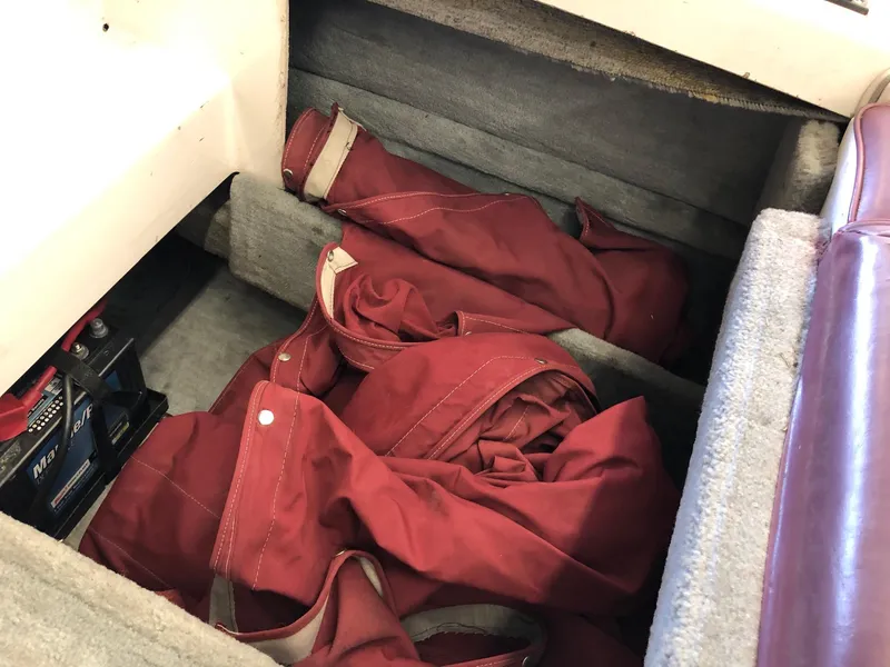 Slide: The Image of Storage compartment of 1992 Four Winns 220 Horizon Open Bow with red canvas covers. - 9