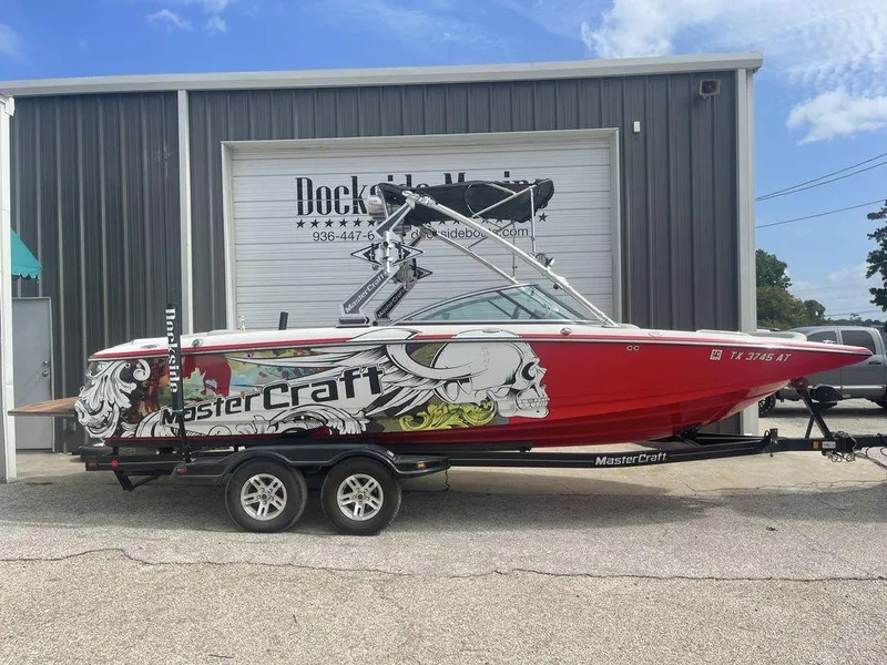 Slide: The Image of 2008 MasterCraft X45 boat with custom graphics on trailer outside Dockside Marine. - 0
