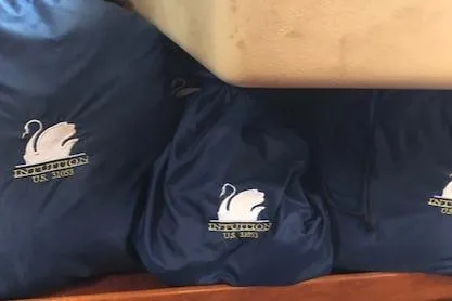 Slide: The Image of Blue bags with swan logo, labeled "INTUITION," on a Nautor Swan 371 Sloop, 1981. - 12