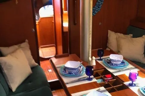 Slide: The Image of Interior of 1981 Nautor Swan 371 Sloop with dining setup and cozy seating. - 4